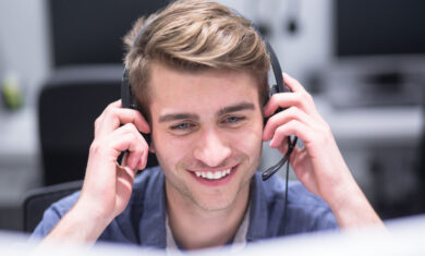 young smiling male call centre operator doing his job with a headset